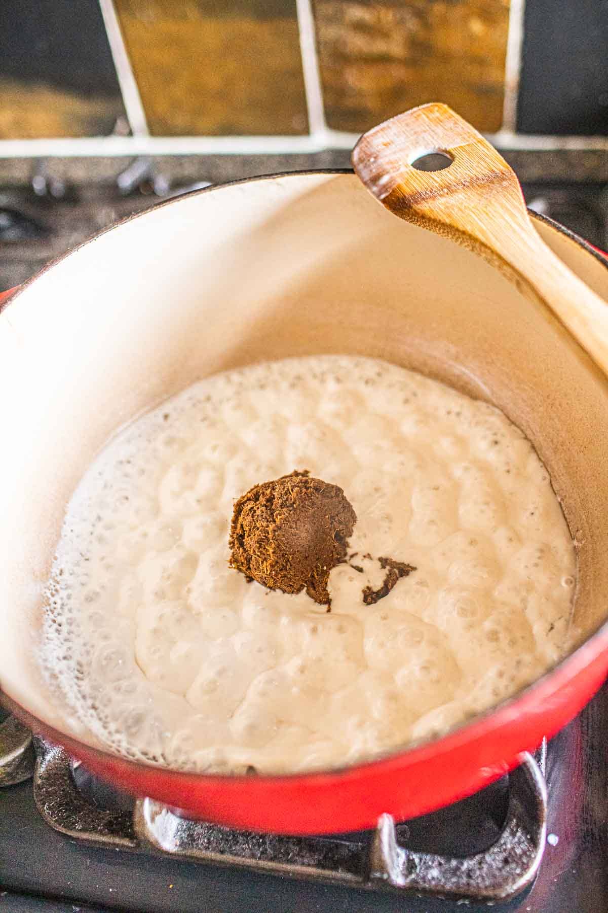 Massaman curry paste with coconut milk in a stock pot. 