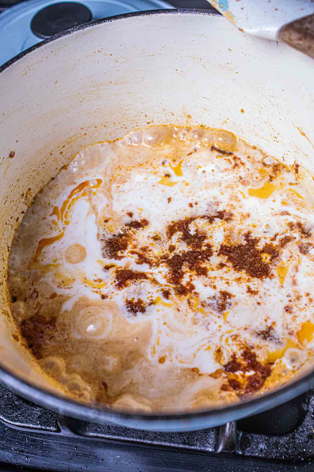 Coconut milk and panang curry paste  in a pot. 