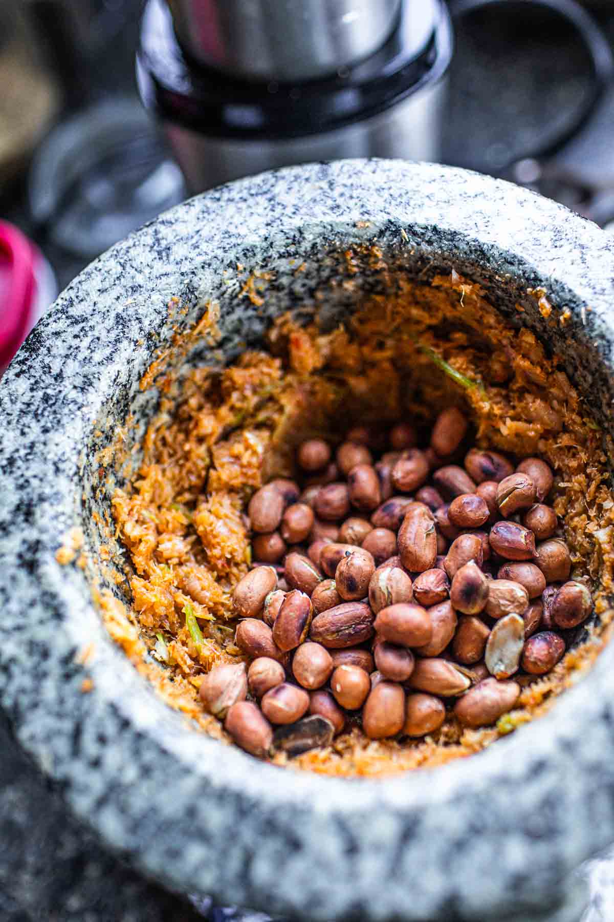 Peanuts with curry paste in a mortar.