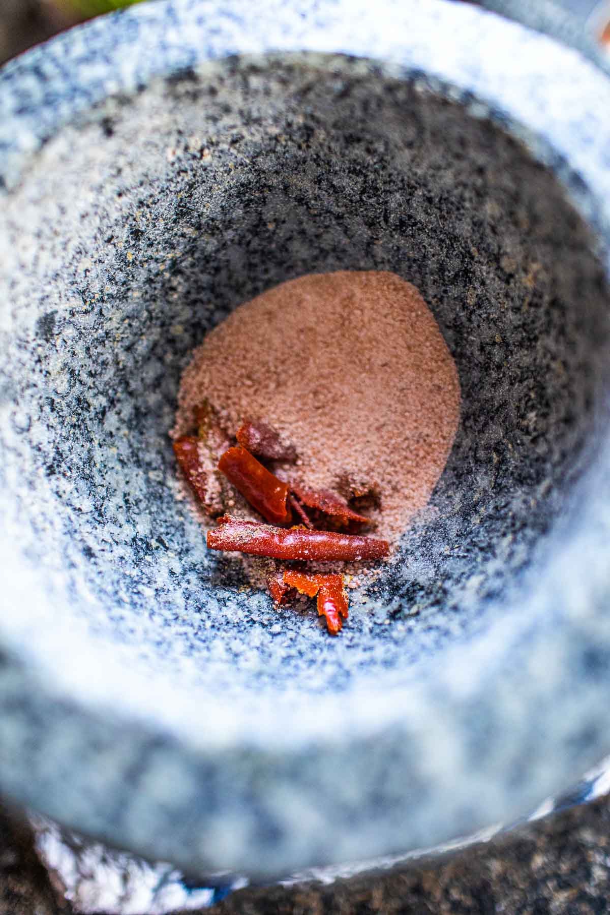 Chili and salt with curry paste in a mortar.