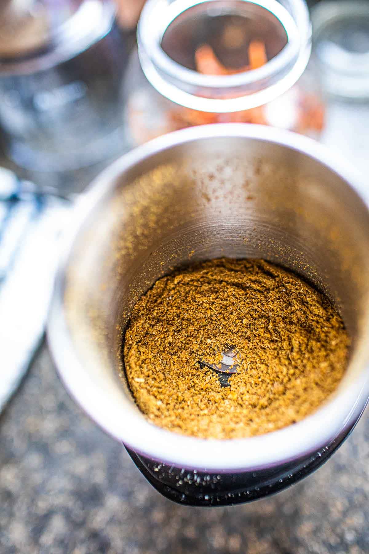 Ground spices with curry paste in a spice grinder. 