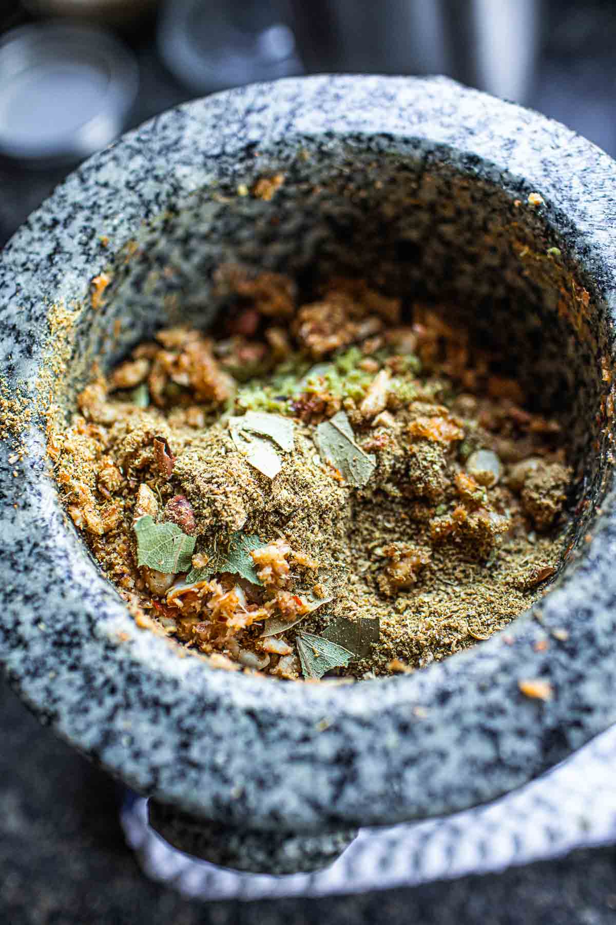 Ground spices with curry paste in a mortar.