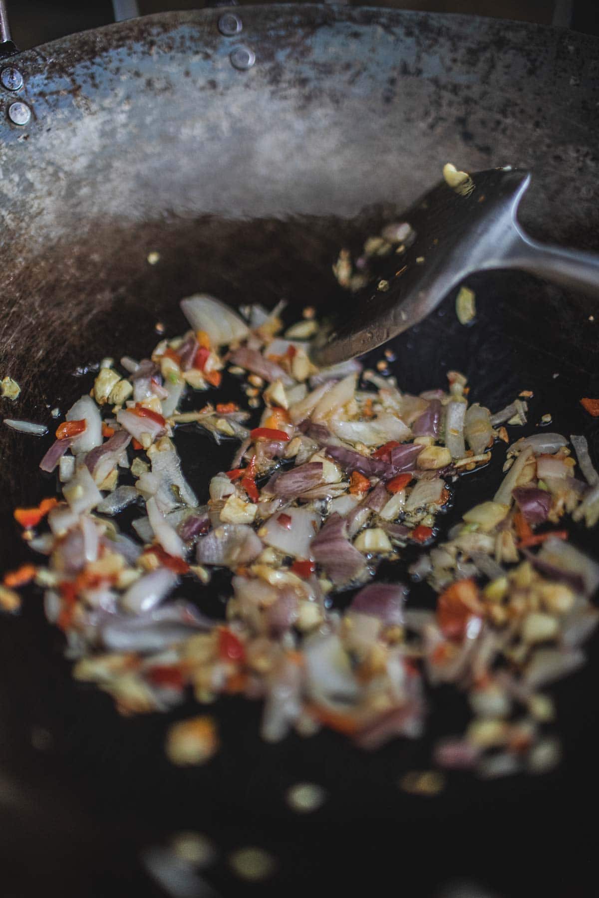 Frying shallot, garlic and chilies in a wok.