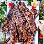 Thai grilled beef ribs on a platter on the table.