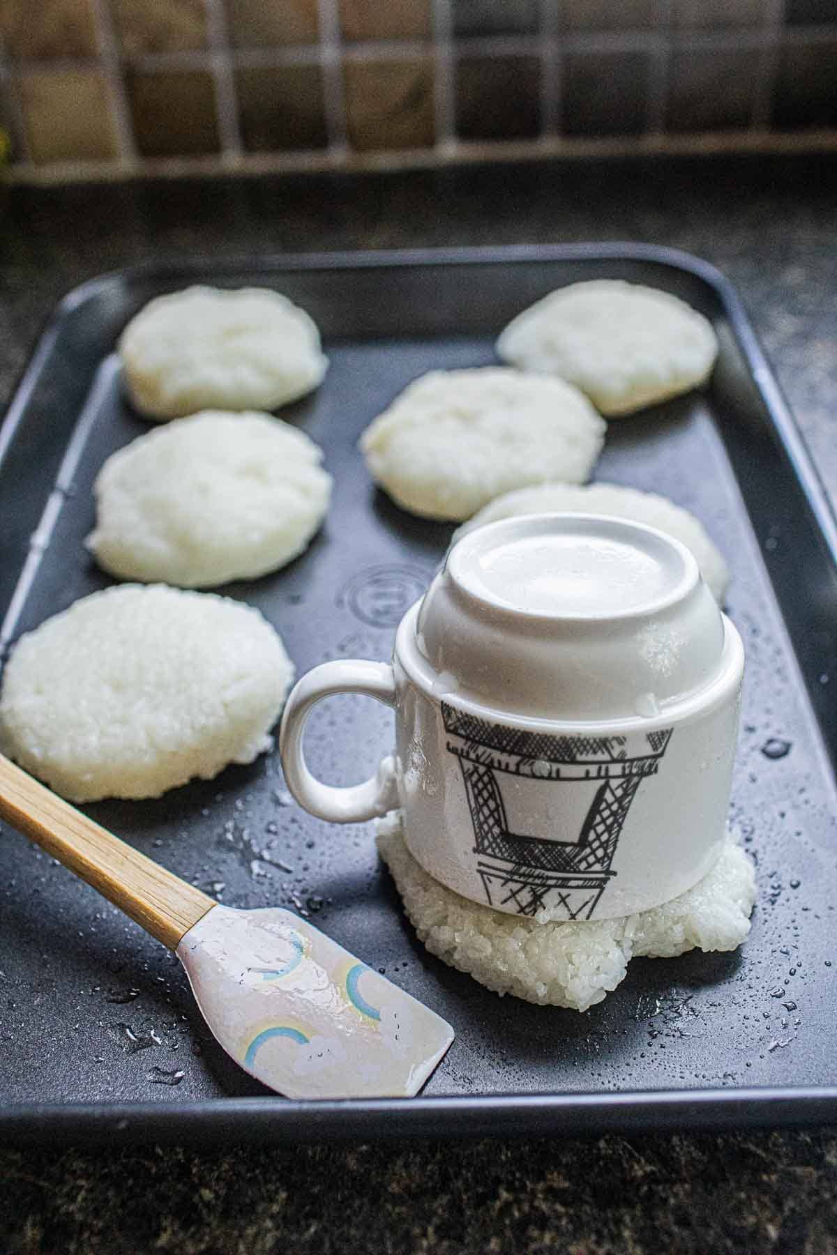 Cups shaping sticky rice patties.