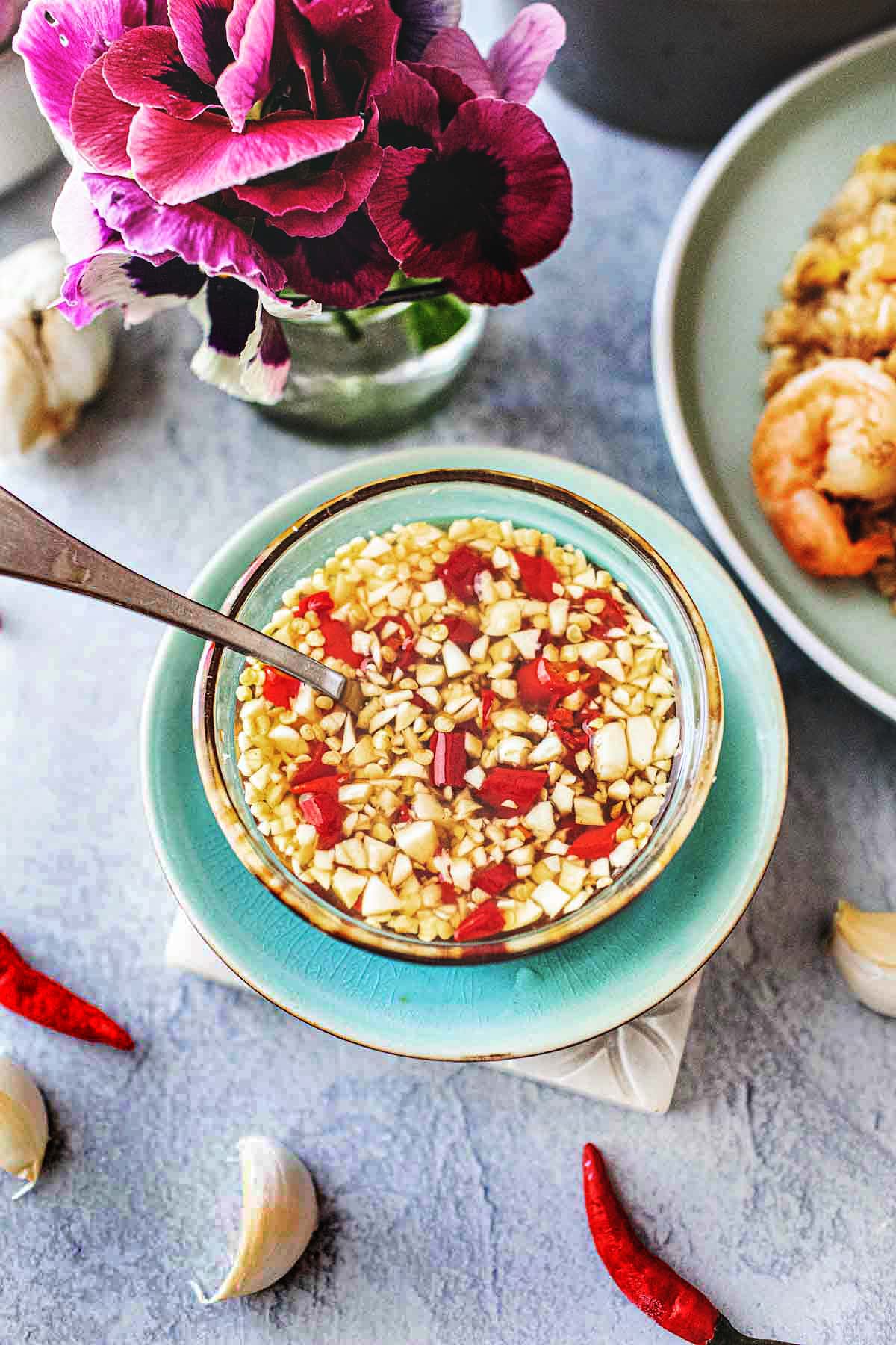 Spoon in a small bowl with Thai nam Prik Pla sauce.