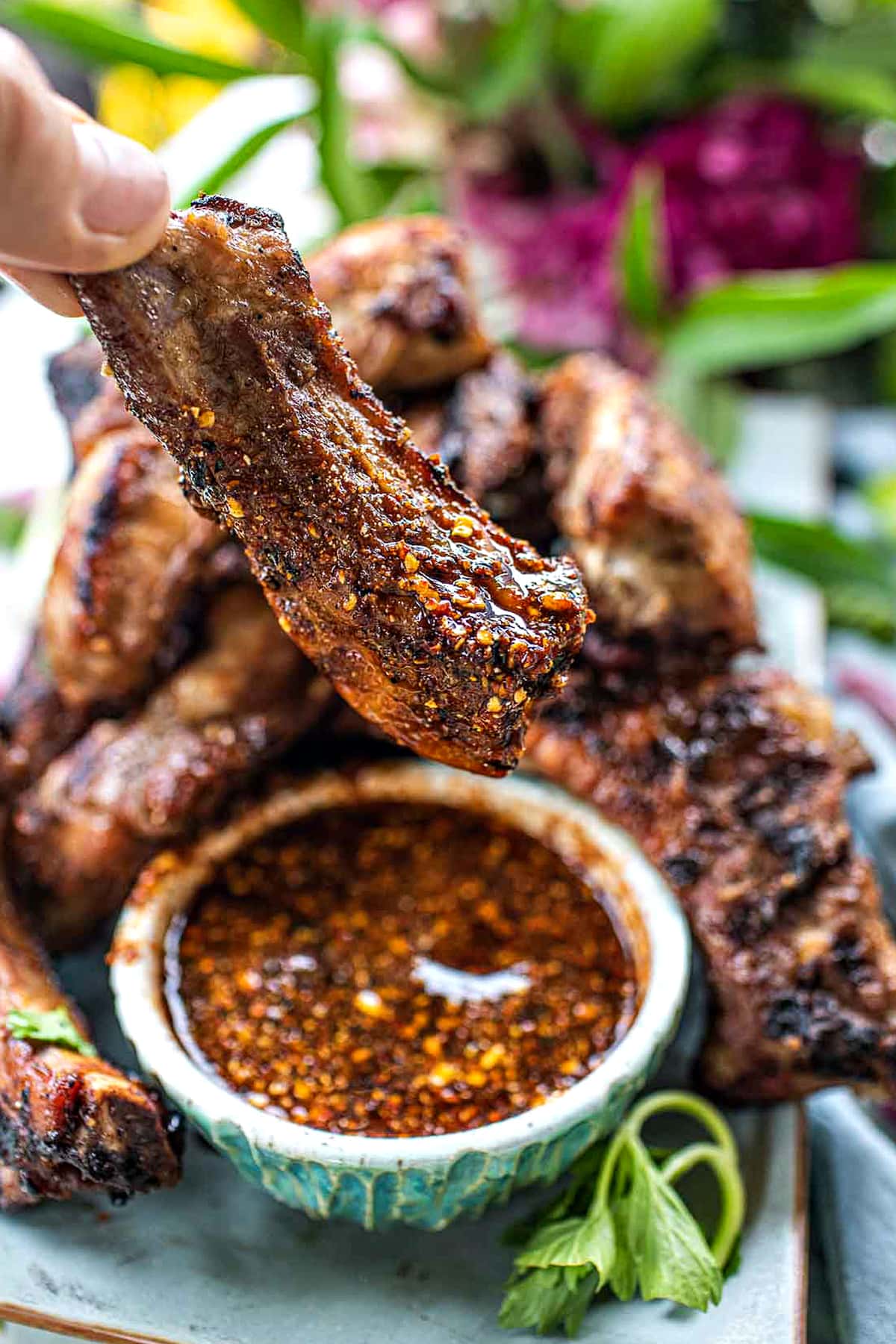 Thai bbq pork ribs lifting from a chili sauce. 