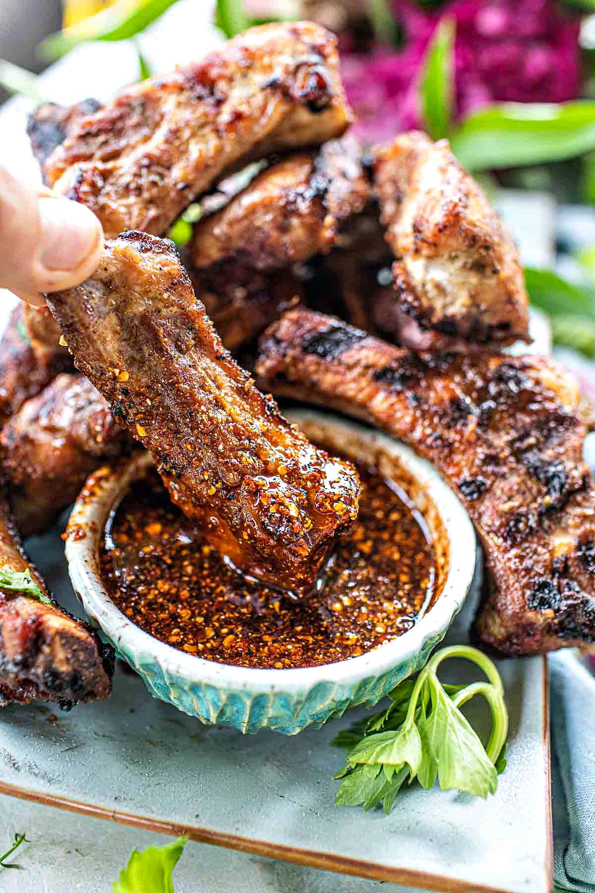 Thai grilled pork ribs on a plate with chili sauce. 