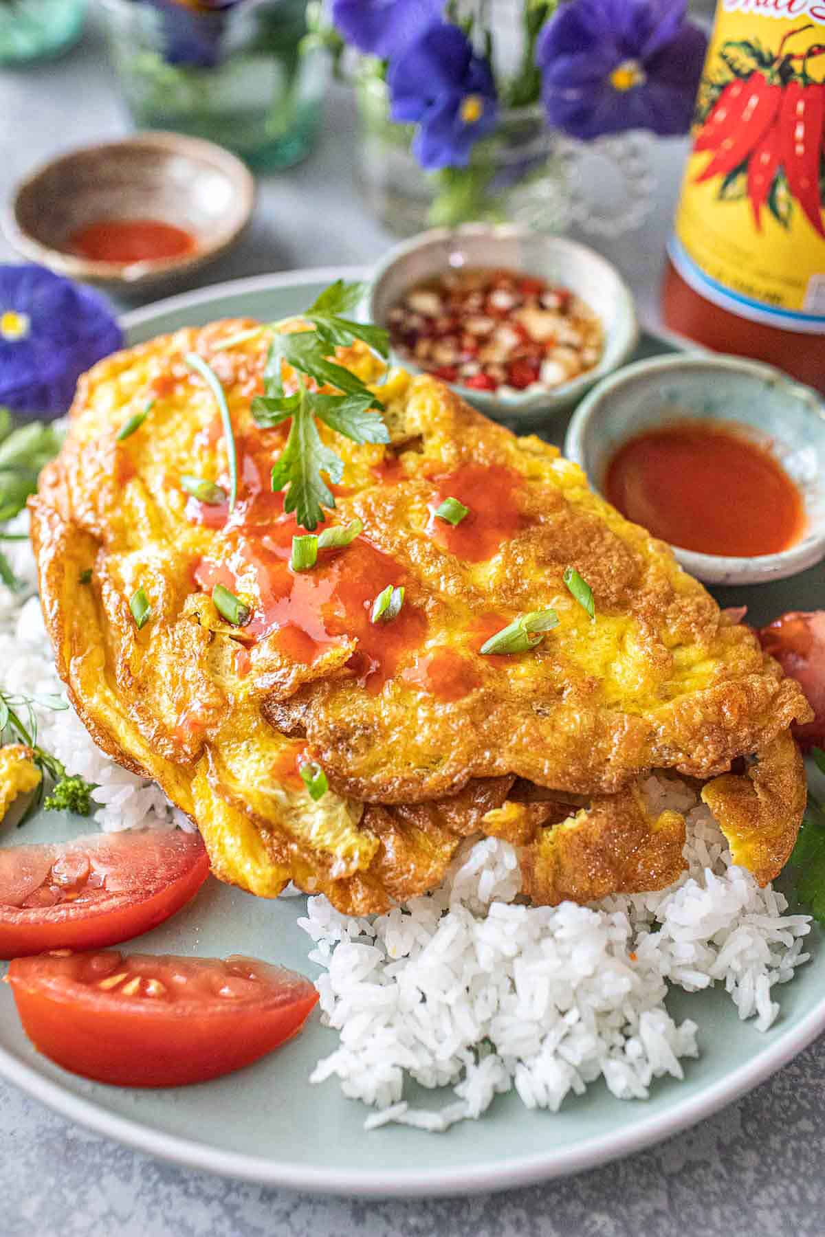Thai omelette over rice with chili sauce on the side.