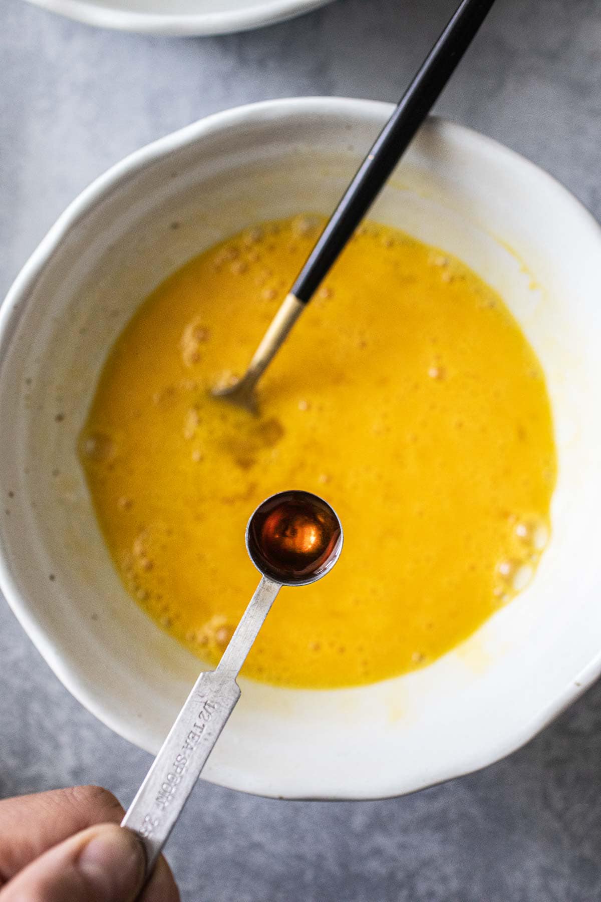 fish sauce added to scramble eggs in a bowl.