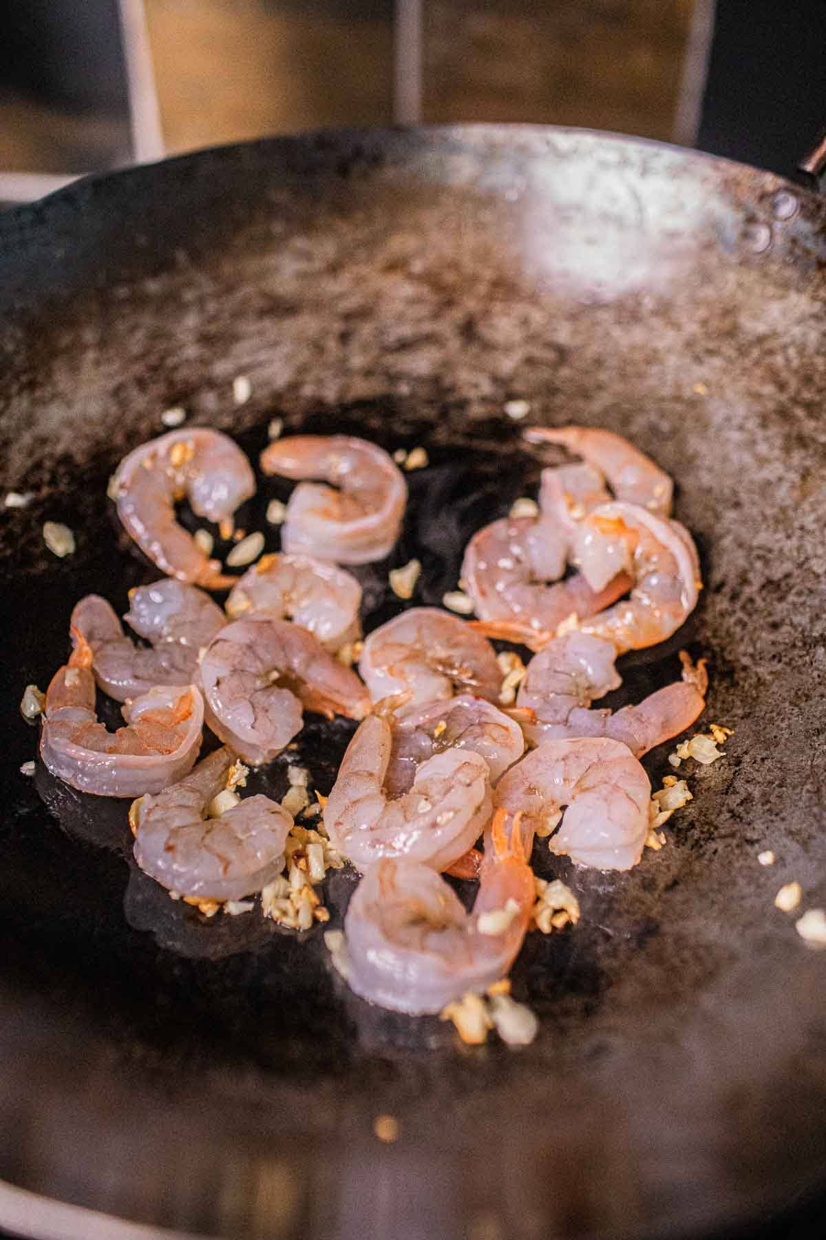 Shrimp and garlic fried in a wok. 