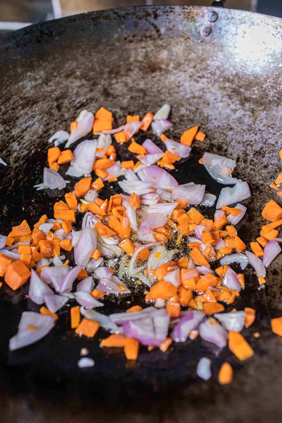 Fried shallot and carrot in a wok.