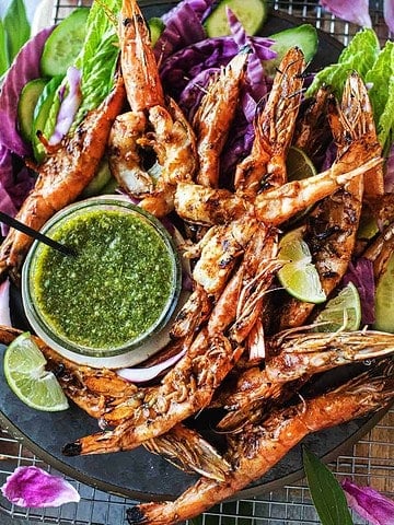 Thai grilled shrimp on a plater with green sauce.