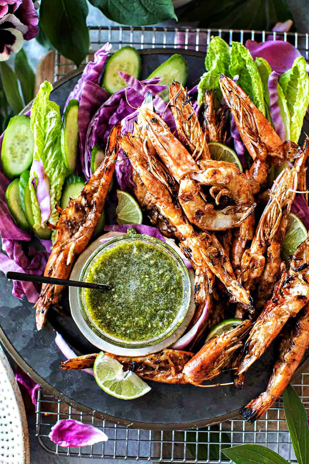 Thai grilled shrimp on a plate with green dipping sauce.