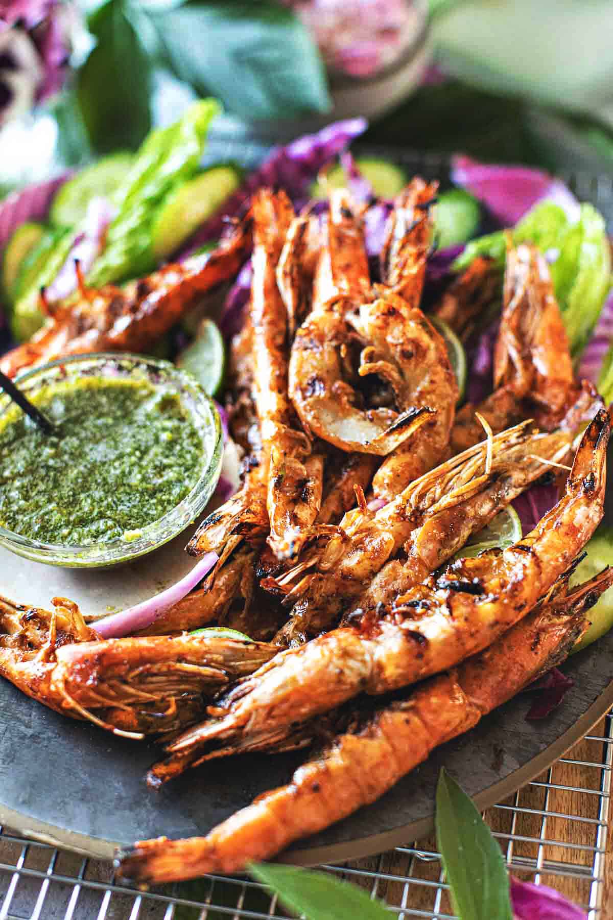 Thai grilled shrimp on a platter with green sauce. 