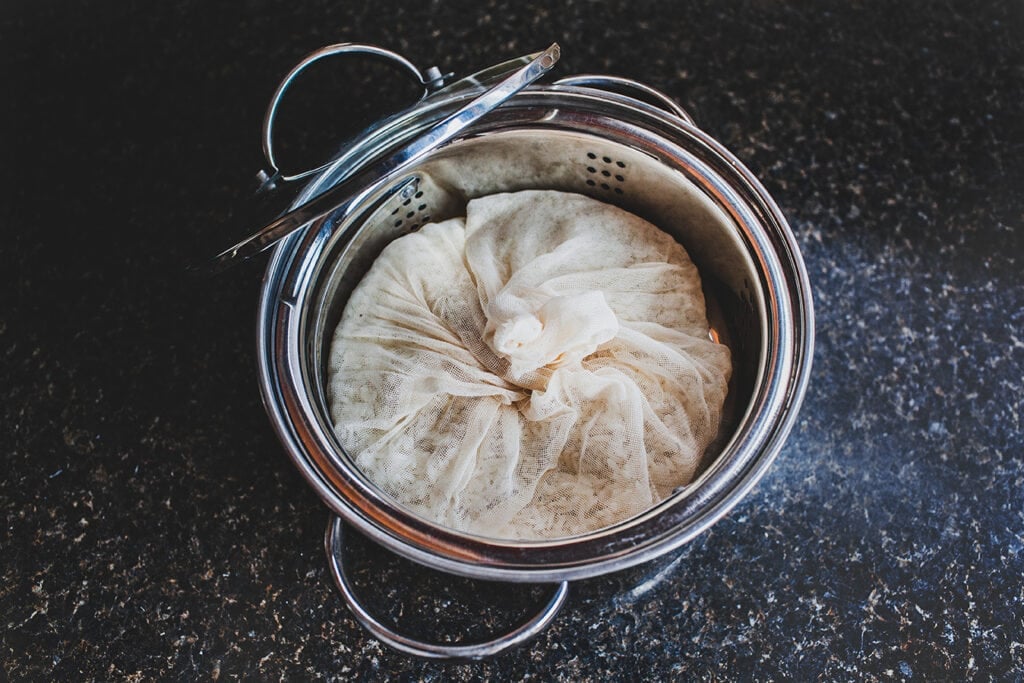 Thai sticky rice wrapped in a cheese cloth in a pan.