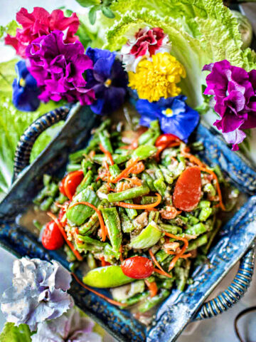 Green bean salad in a plate with flower decorations on the side.