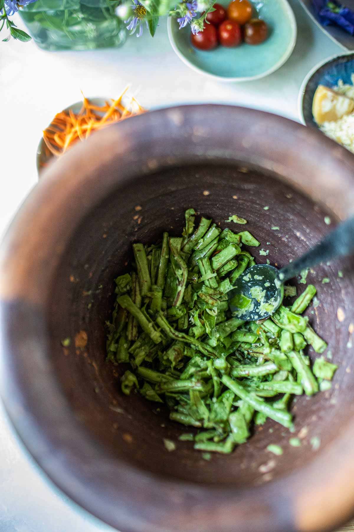 Smashed green beans in a mortar.