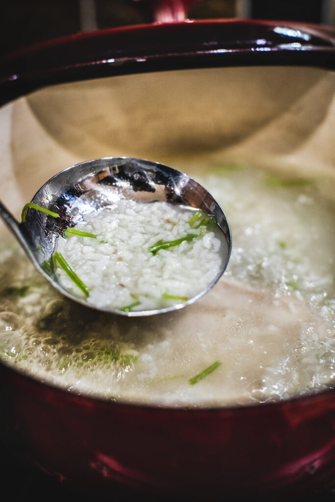 Spoon scooping rice from a pot.