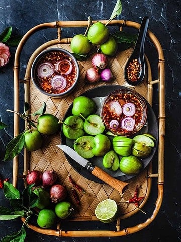 Thai mango dipping sauce on a tray with mangos.