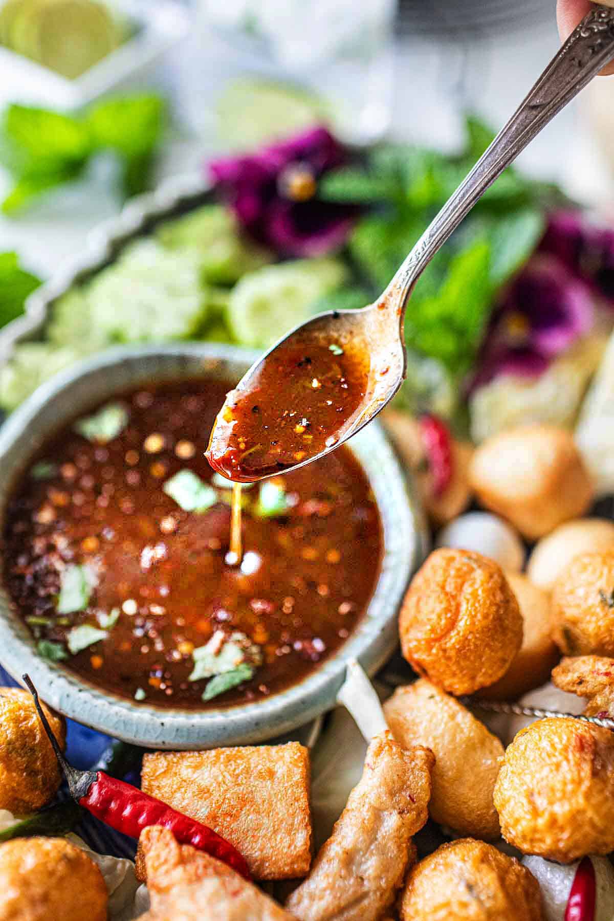 Tamarind dipping sauce dripping from a spoon. 