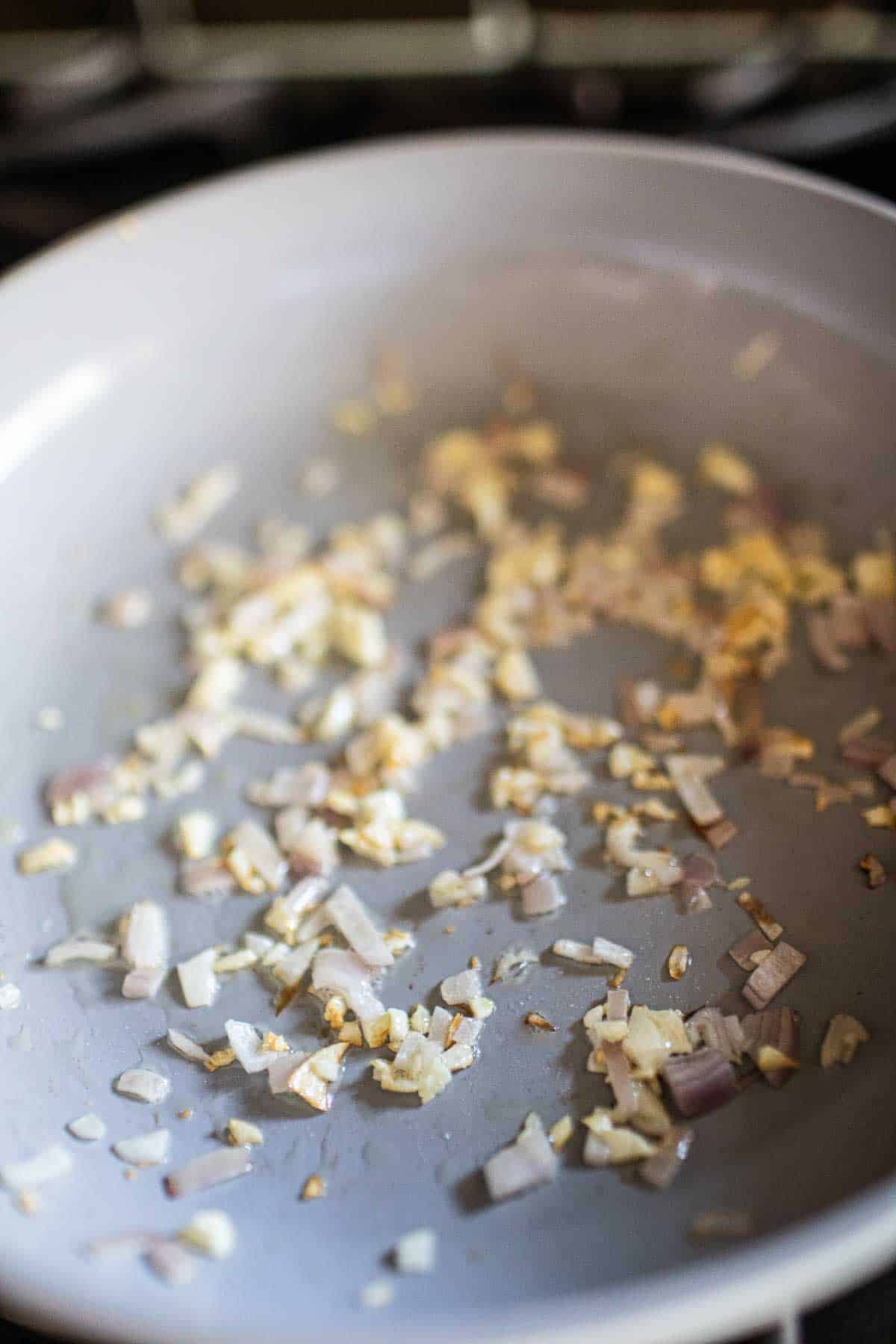 garlic and shallot frying in a pan. 