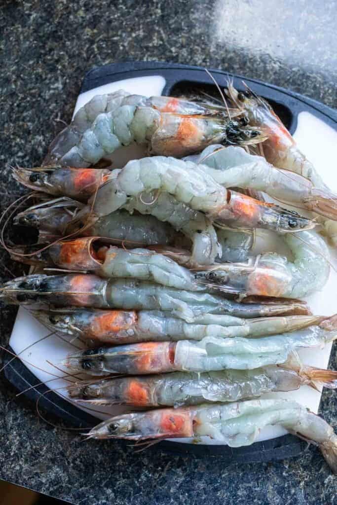 Deveining shrimp on a cutting board.