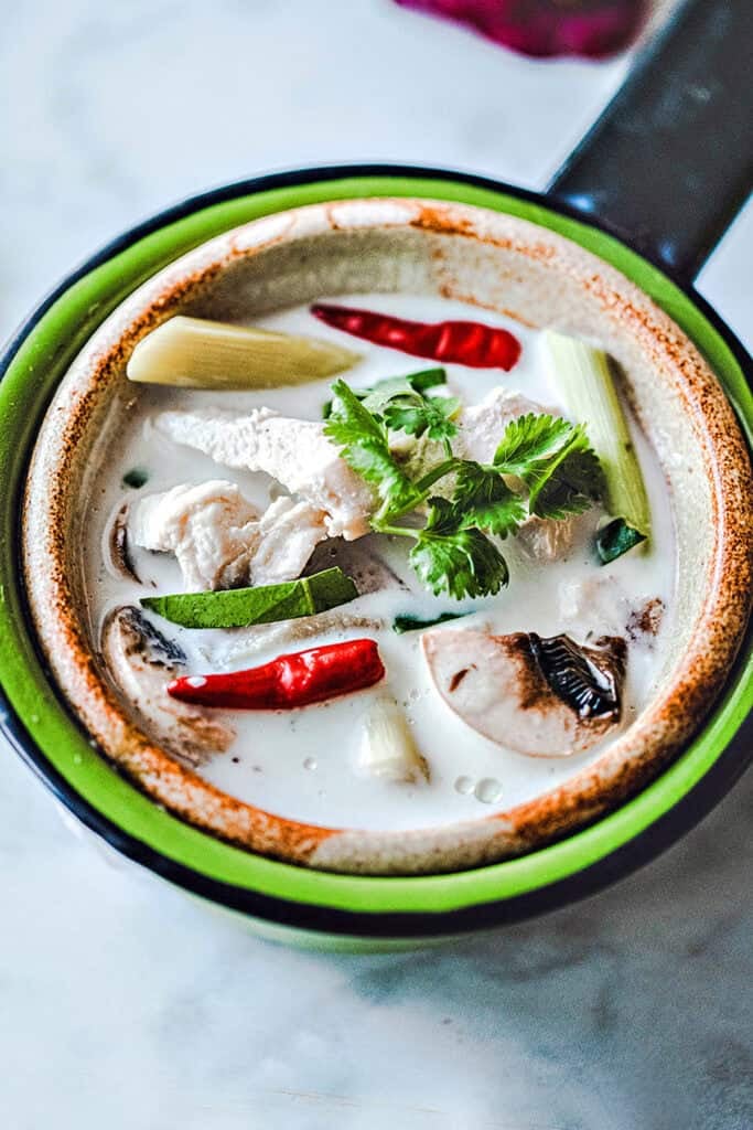 Chicken Tom Kha Gai in a bowl on the table.