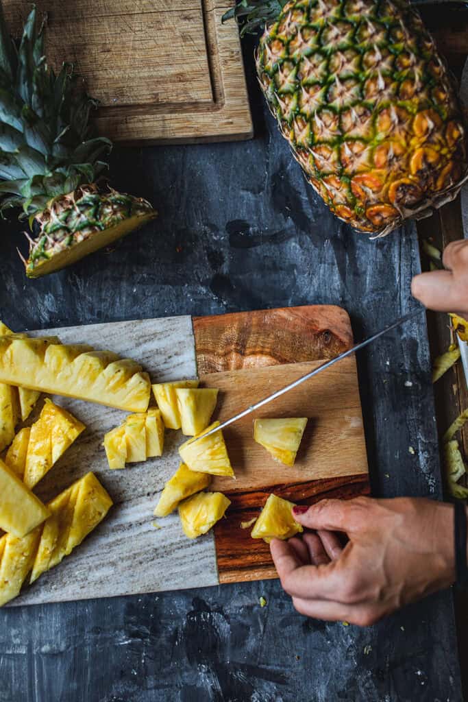 Cutting pineapole into small pieces.