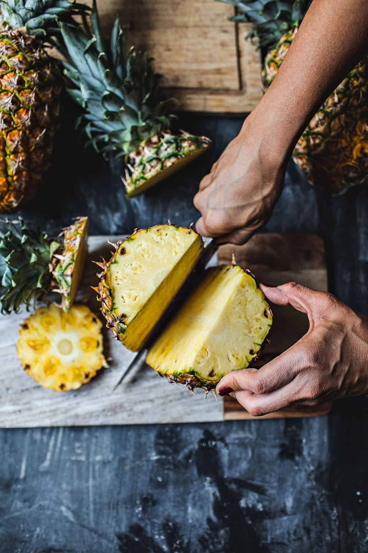 Cutting a pineapple in half.