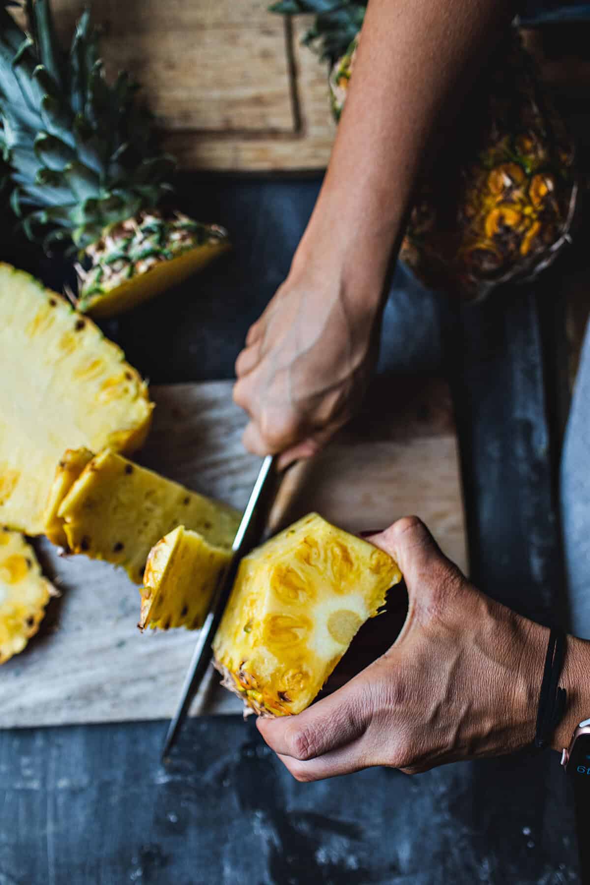 Cutting the skin of pineapple. 