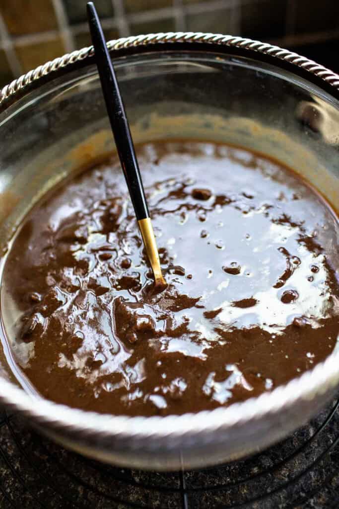 A fork inside Tamarind paste in a glass bowl.