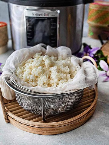 Sticky rice steaming in bamboo baskets over a taoloh at the