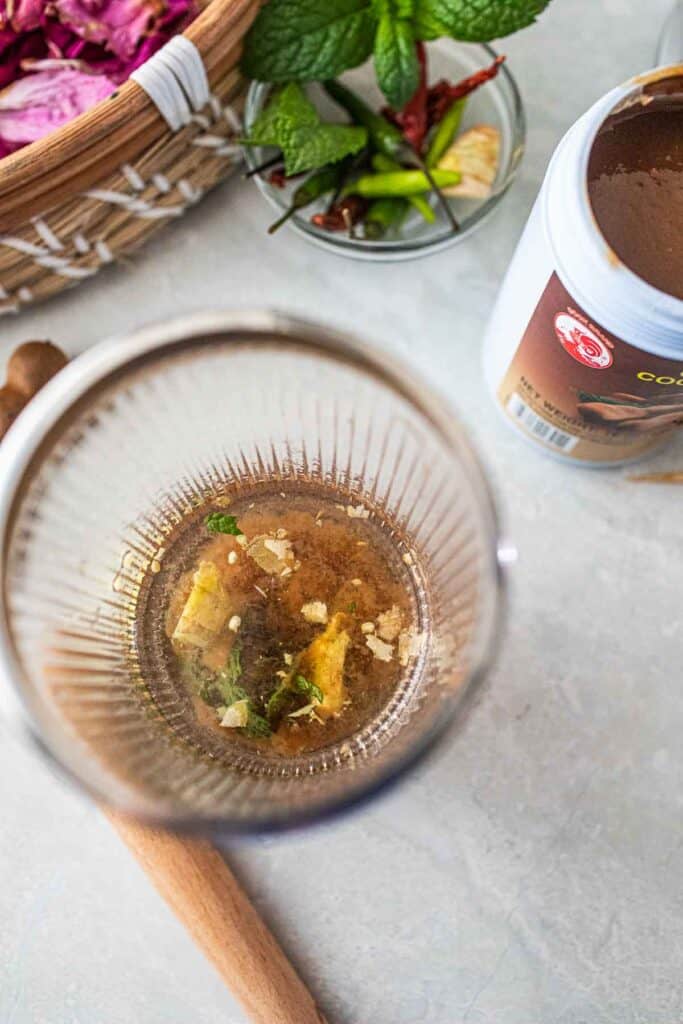 liquids and herbs in a shaker for Tamarind drink.