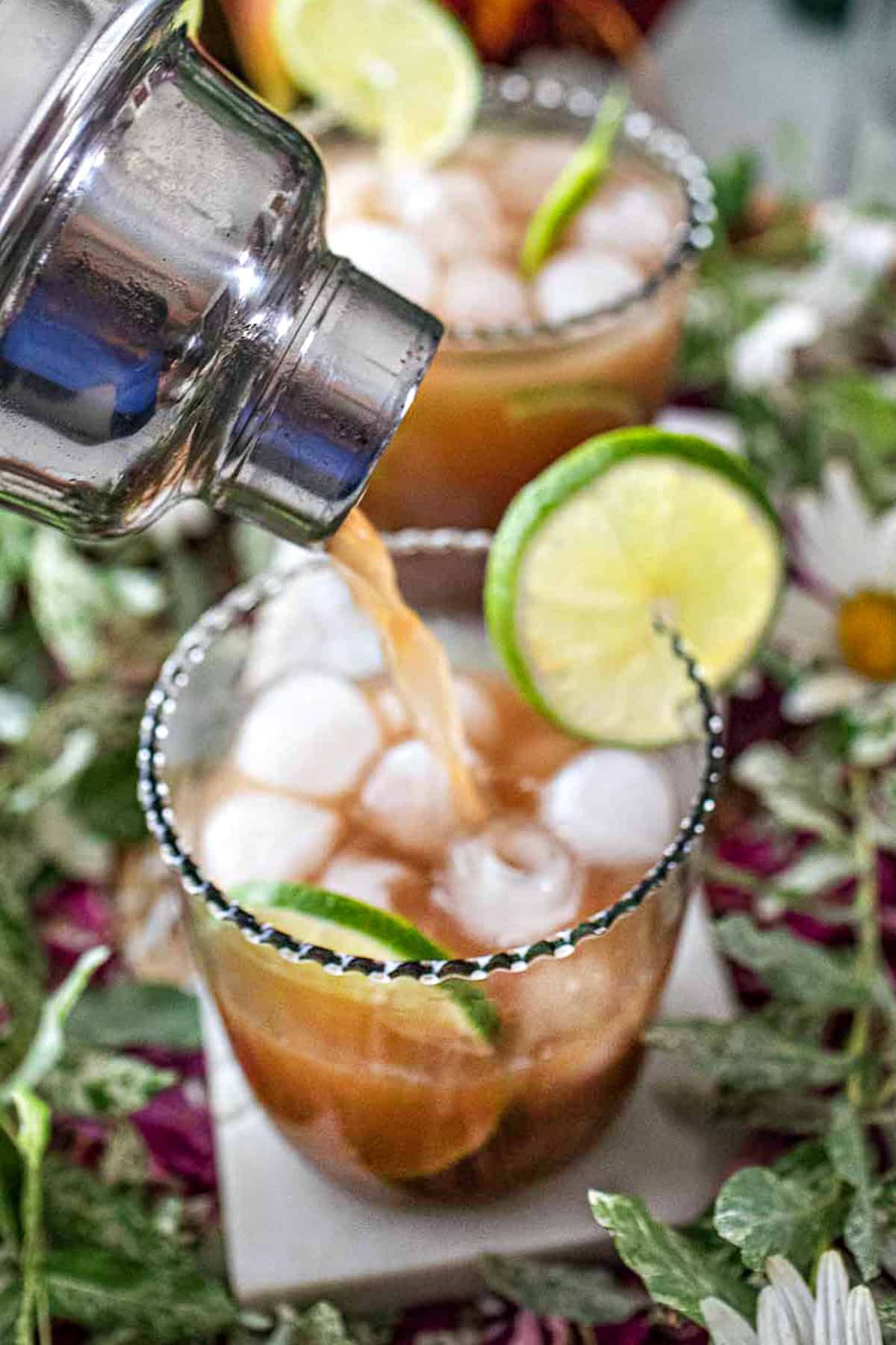 Tamarind cocktail pouring into a cocktail glass. 