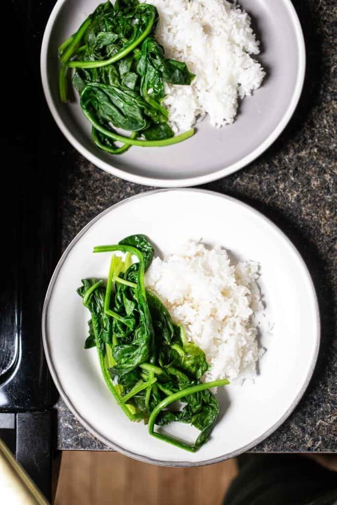 Spinach over 2 plates of rice. 