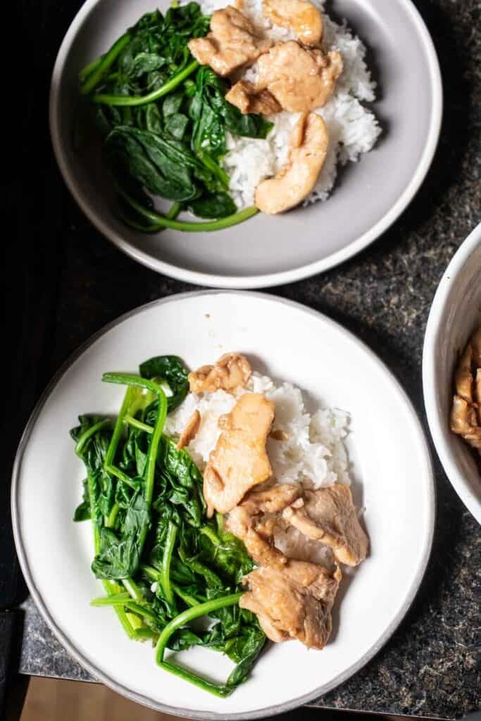 chicken and spinach over 2 plates of rice. 