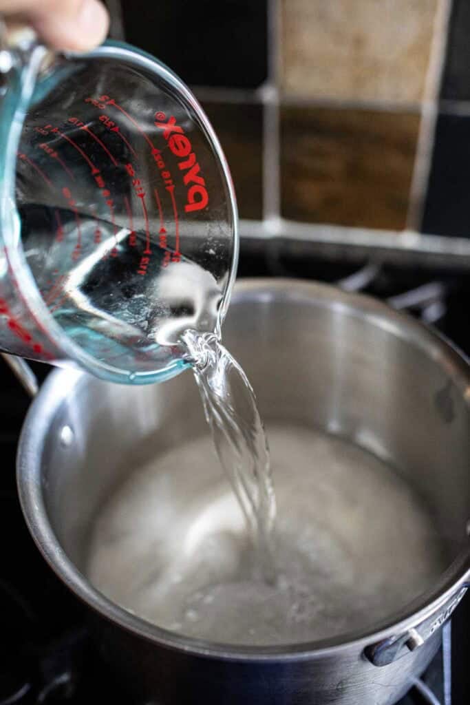 water pouring into a pot with sugar water. 