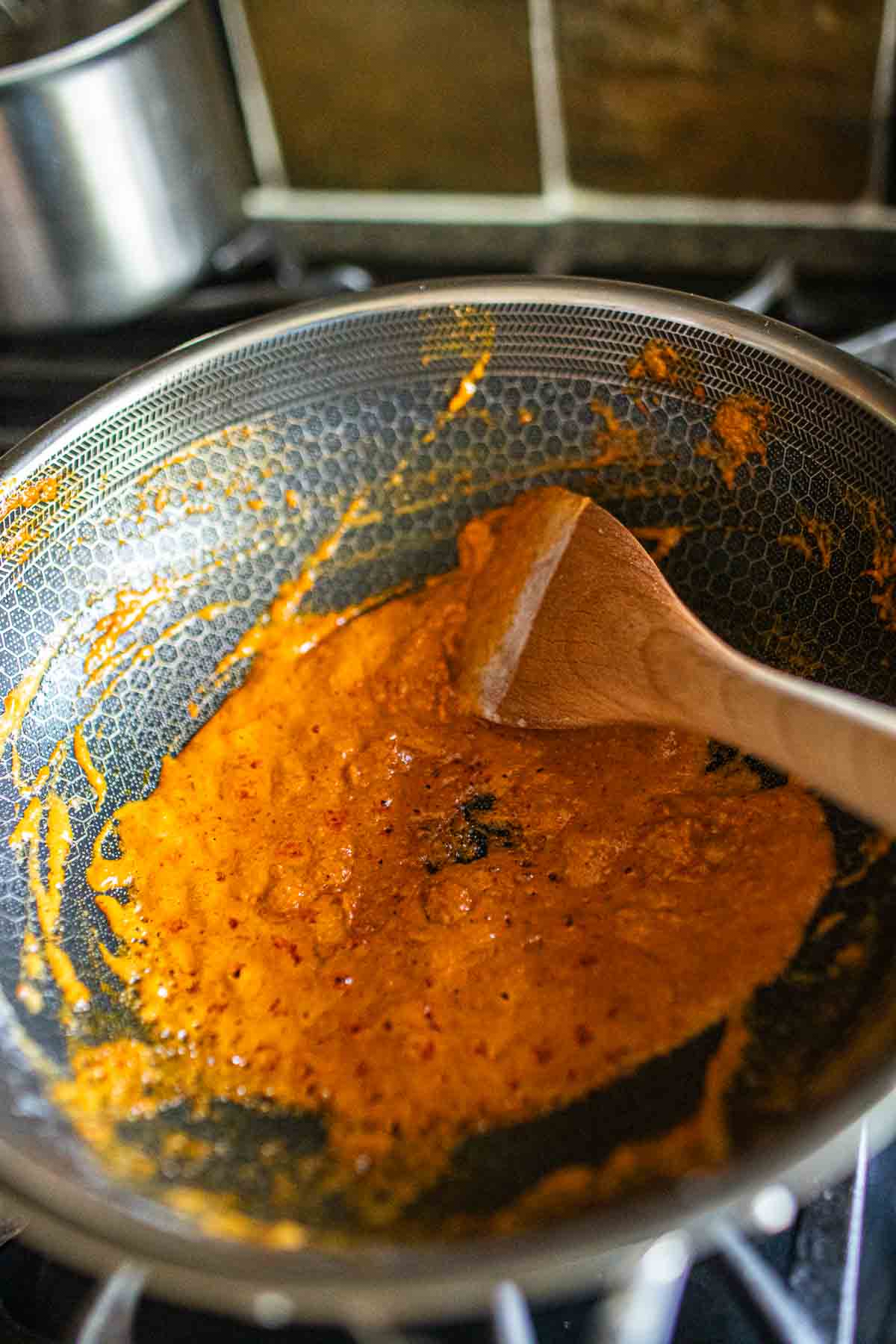 Thai red curry paste cooking in a wok.