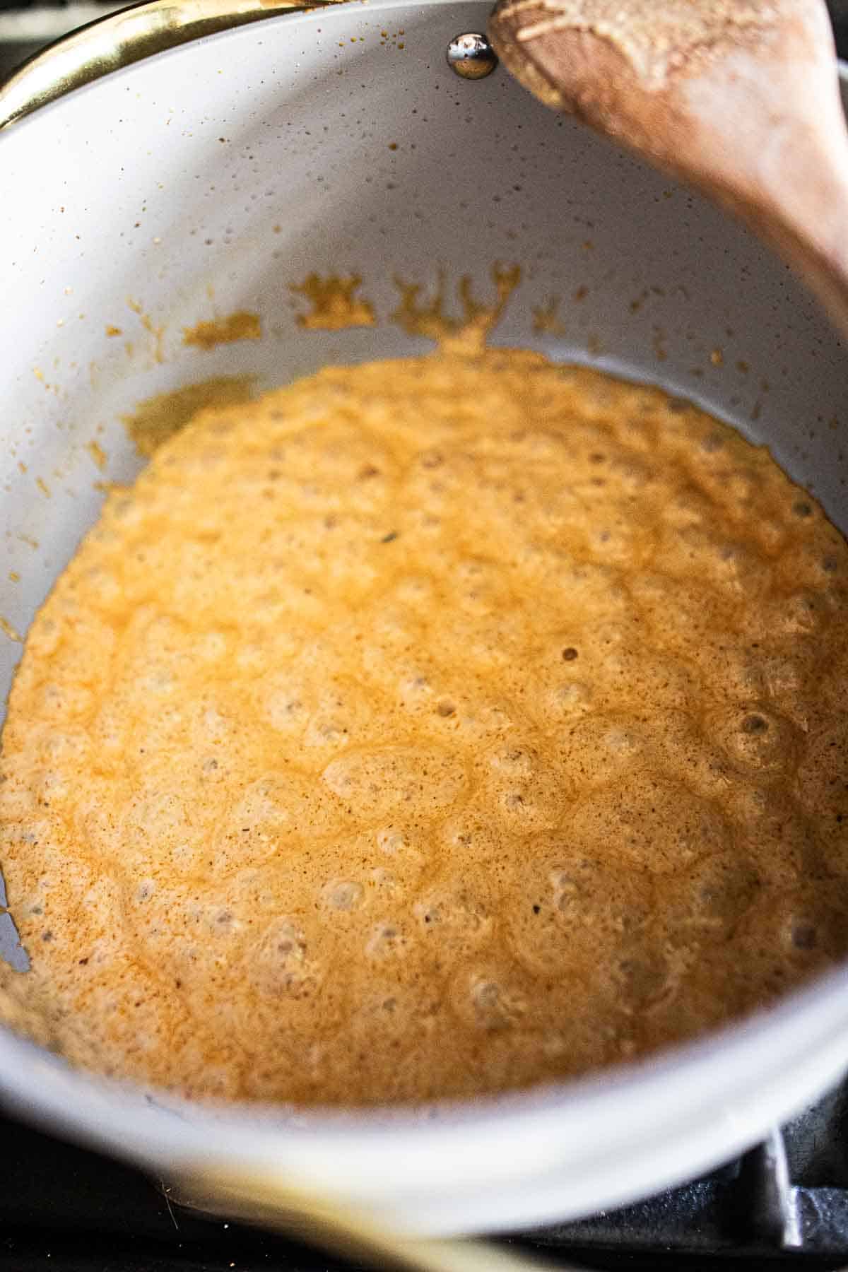 Coconut milk in a pot on the stove.