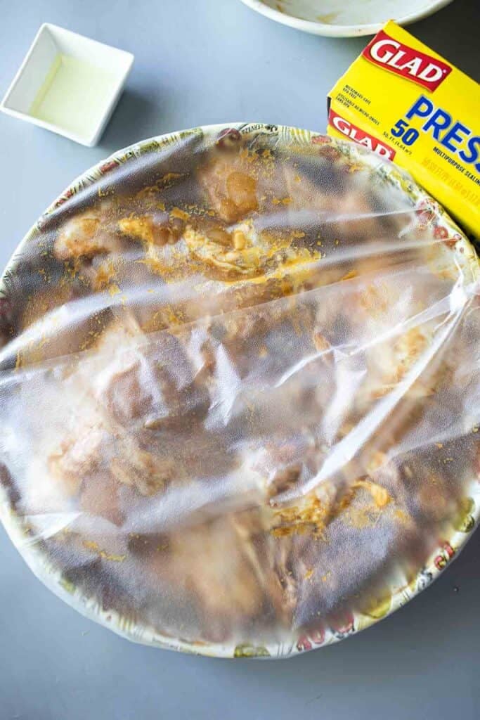 Chicken in Gai Yang marinating sauce wrap in plastic. 