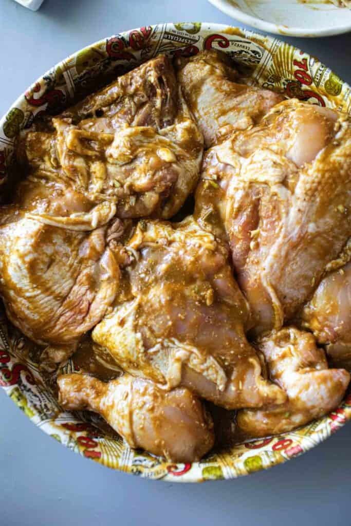 Chicken in Gai Yang marinating sauce in a pan.