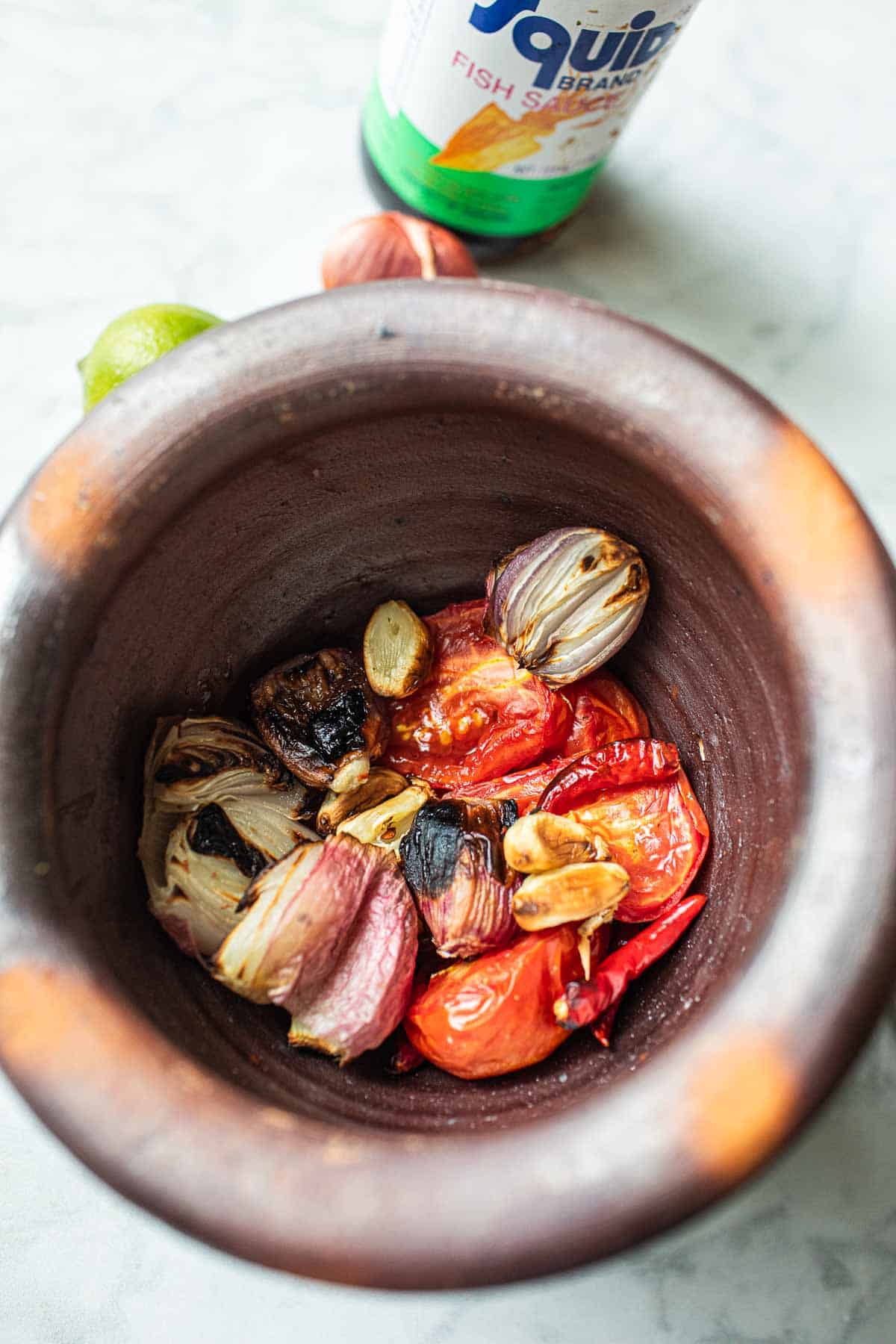 Tomatos, shallot  and garlic in a mortar. 