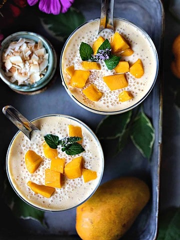 Mango sago in glasses with mango slices on top.