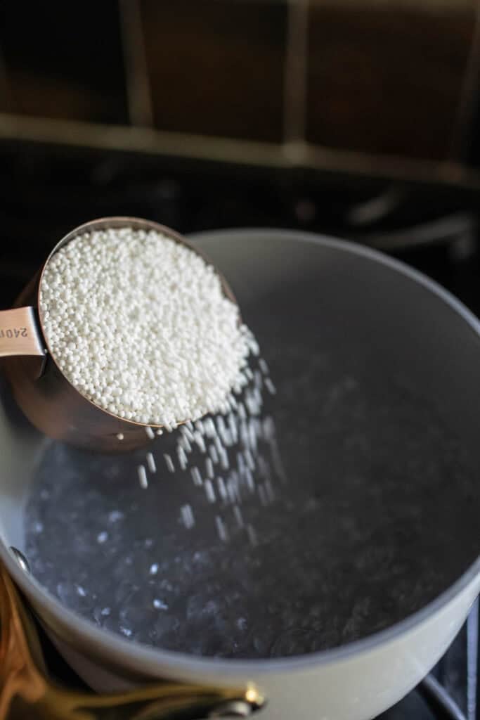 Pouring Mini tapioca pearls into a pot.  