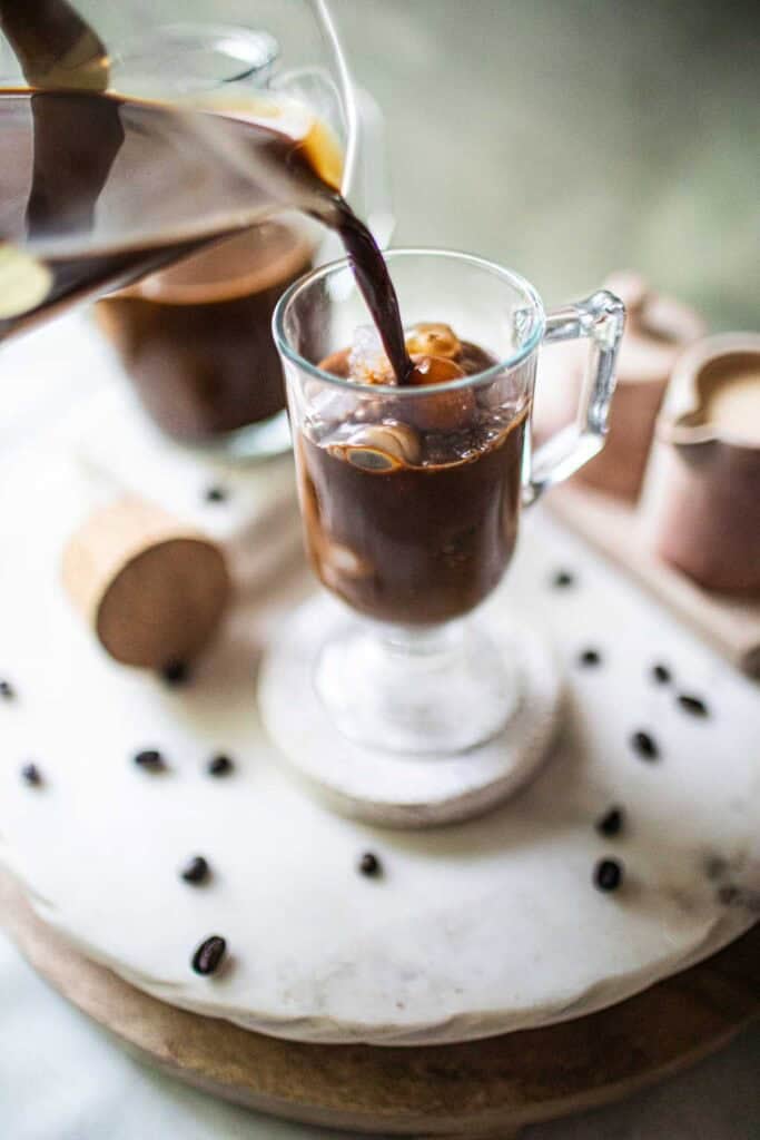 Coffee pouring over a glass of ice.