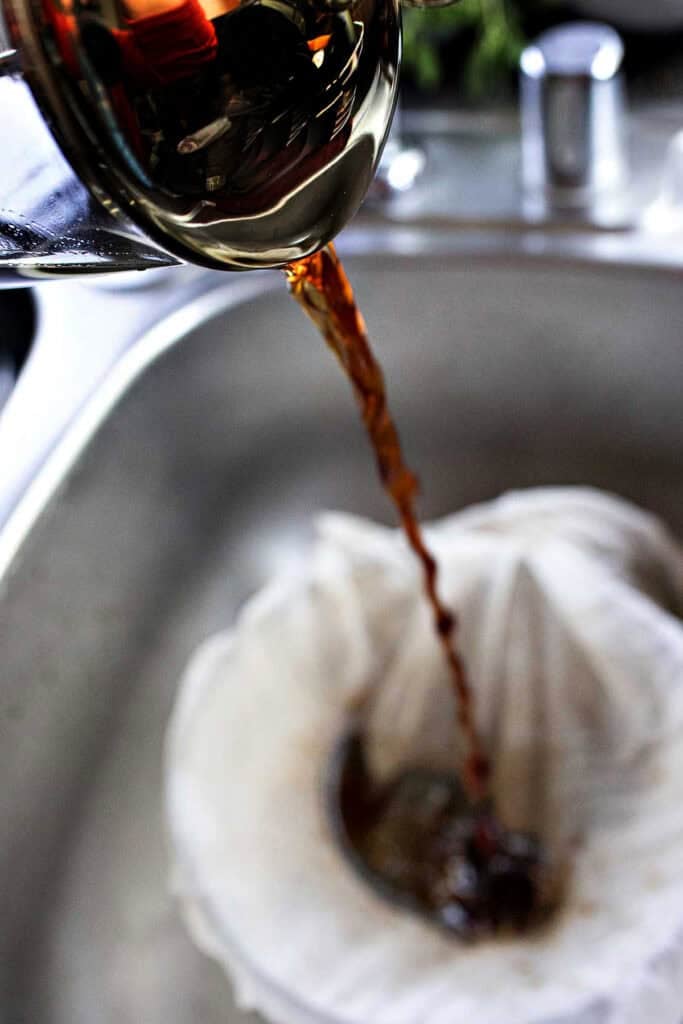 Coffee pouring over cheese cloth into a bowl.