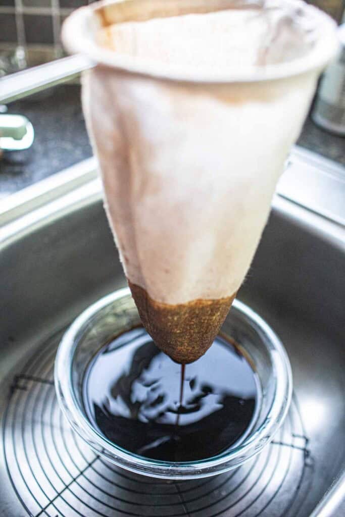 Thai tea sock over a glass bowl. 