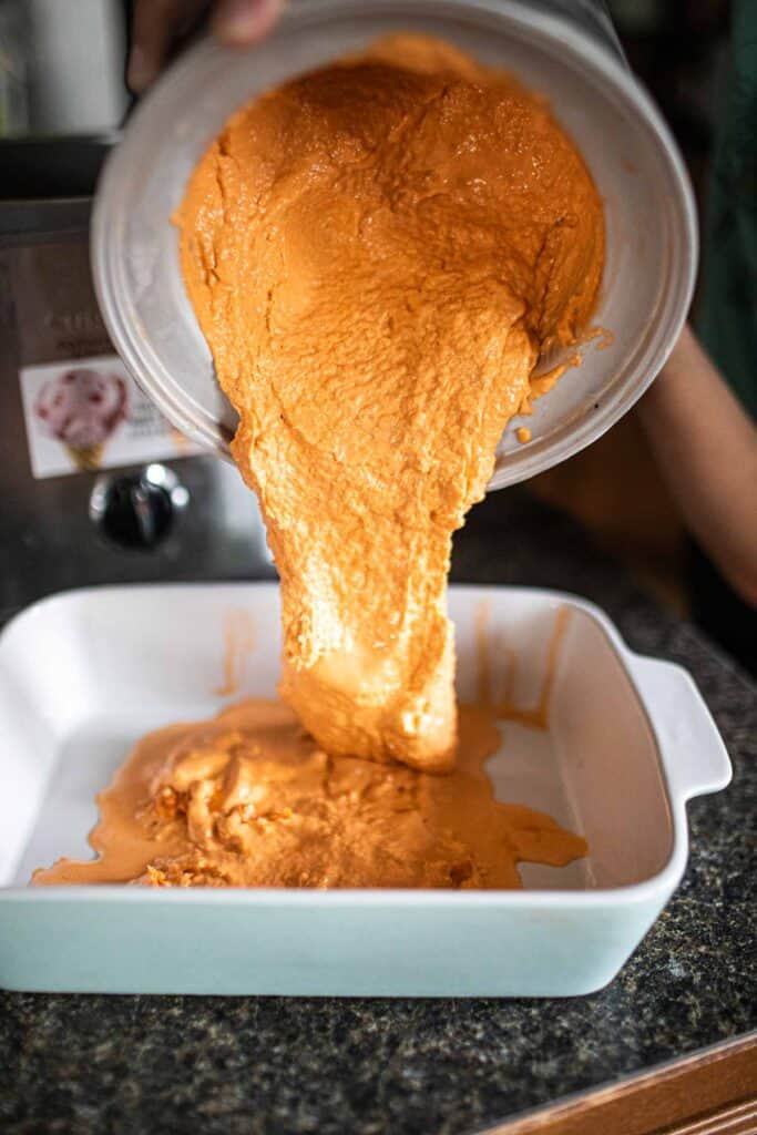 Pouring Thai tea ice cream into a pan.