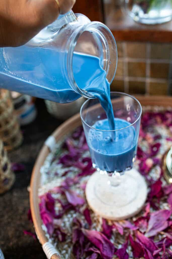 Blue tea pouring into a glass. 